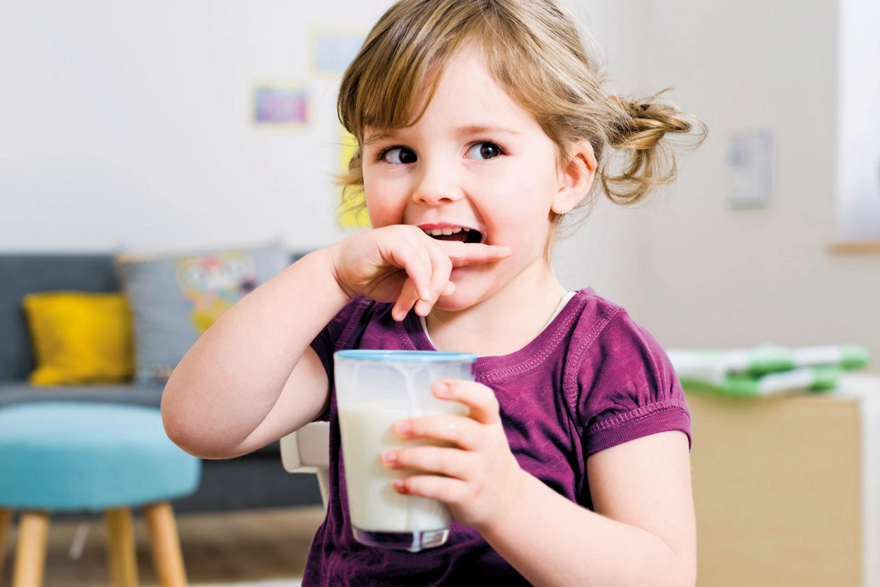 Girl baby drinking milk and biting her finger