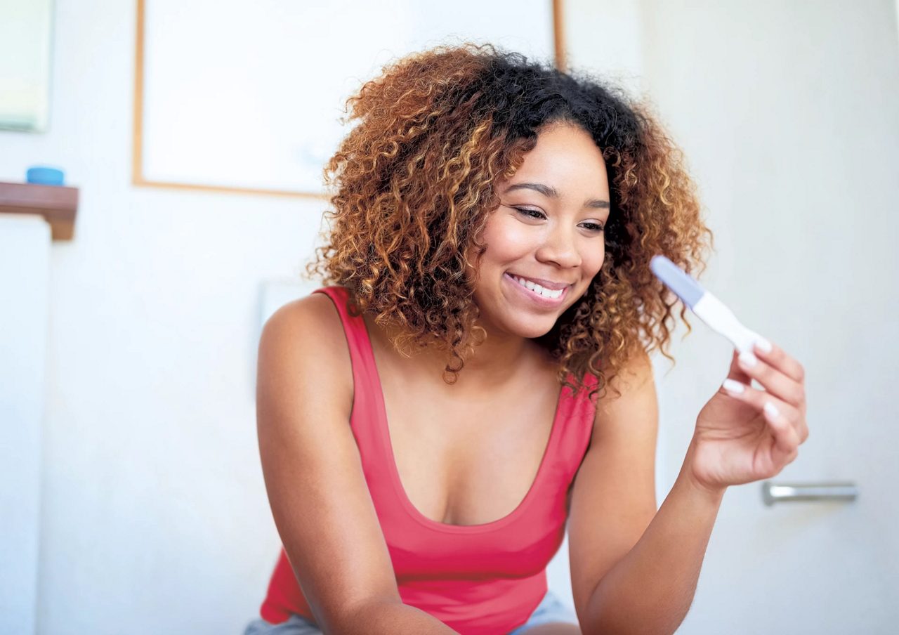 happy woman with pregnancy test