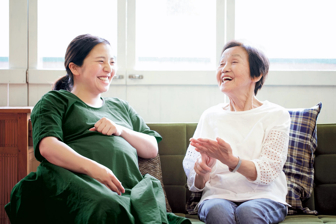 elderly with pregnant woman laughing