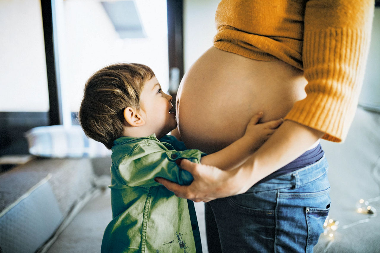 toddler kissing pregnant belly