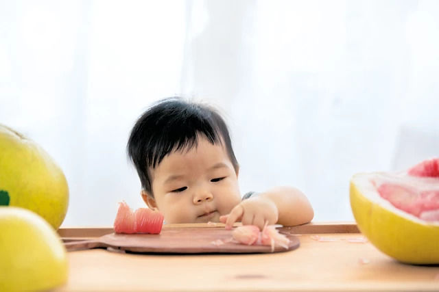 Baby eating from table