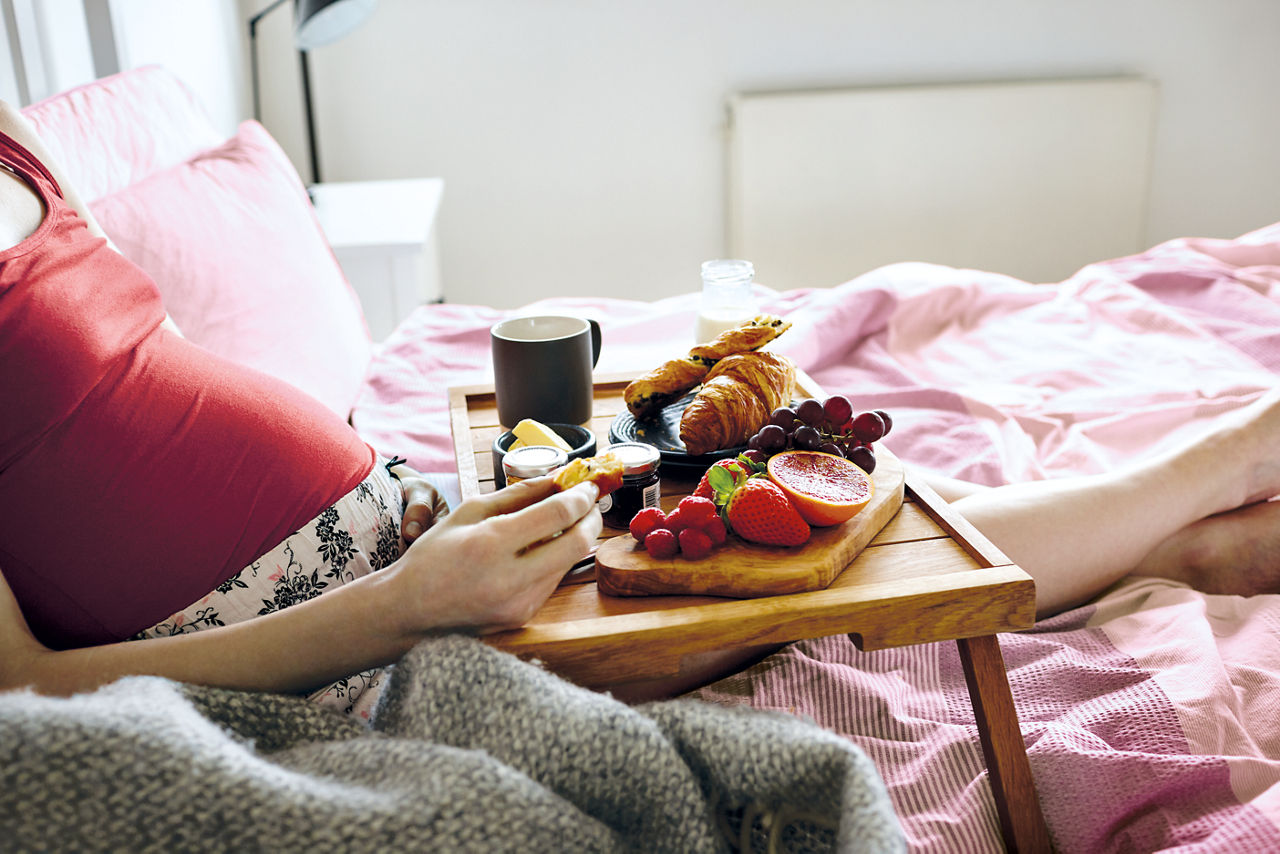 Mum and bump having breakfast in bed