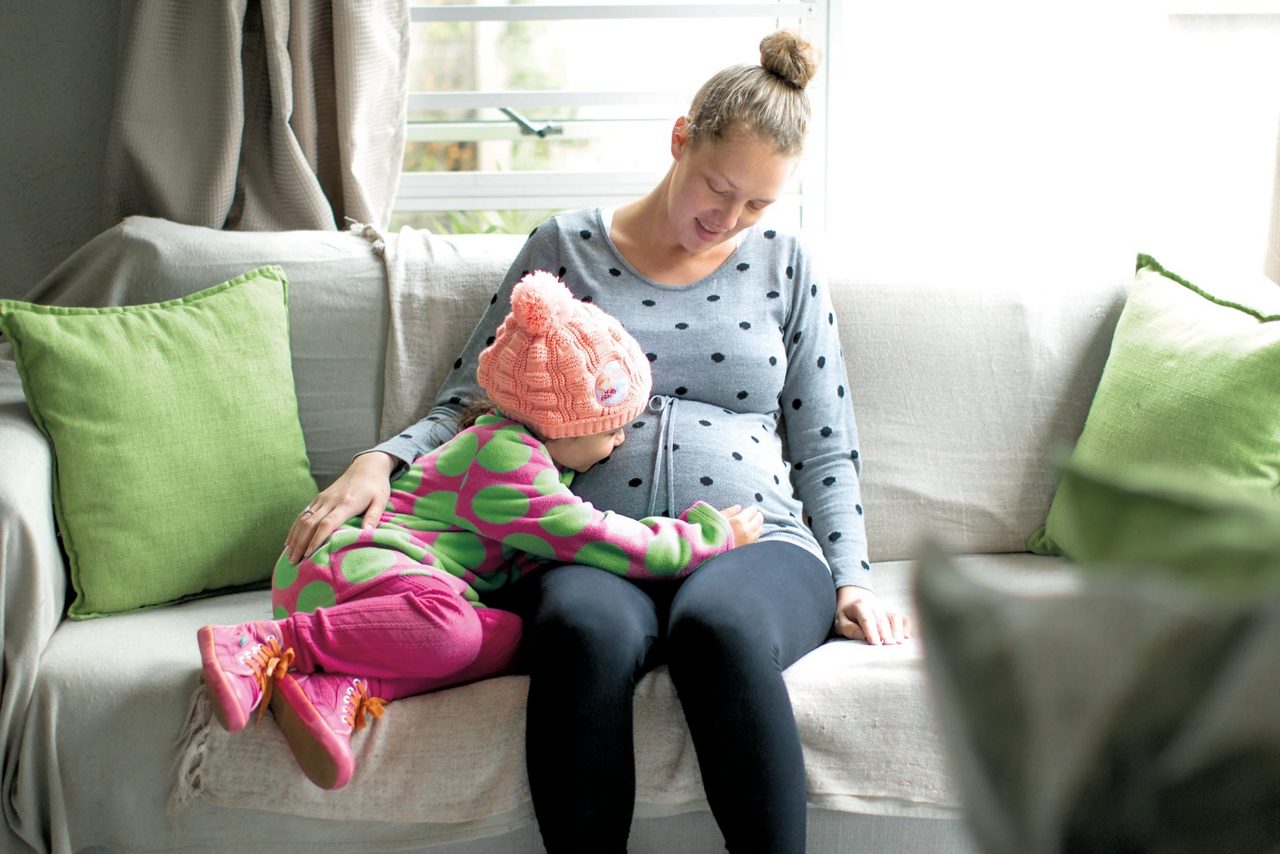 Pregnant woman having breakfast in bed