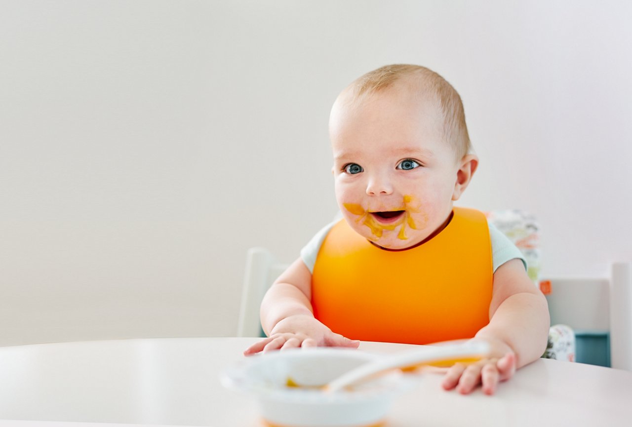 Baby boy sitting at dinning tabel and smiling getty images 927426366