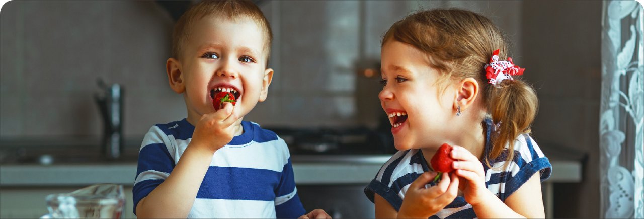 twee peuters lachen en eten