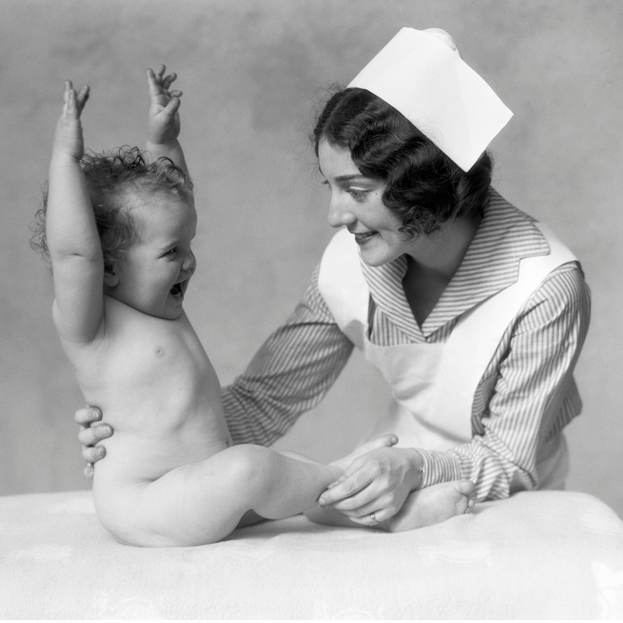 Happy baby with a nurse in a black and white image