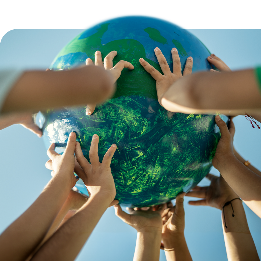 Image de mains d'enfants de différentes origines tenant un globe terrestre peint.