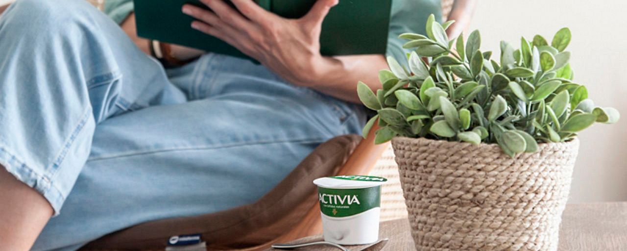 Donna che legge libro in cerca di risposte su Activia