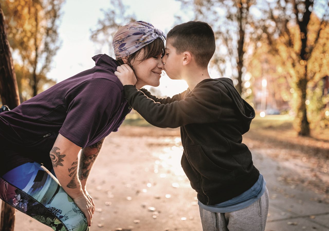 Female Cancer patient being kissed by child