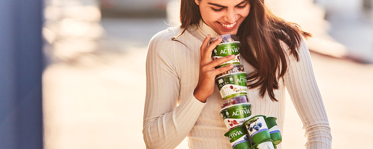 Donna con yogurt Activia di vari gusti