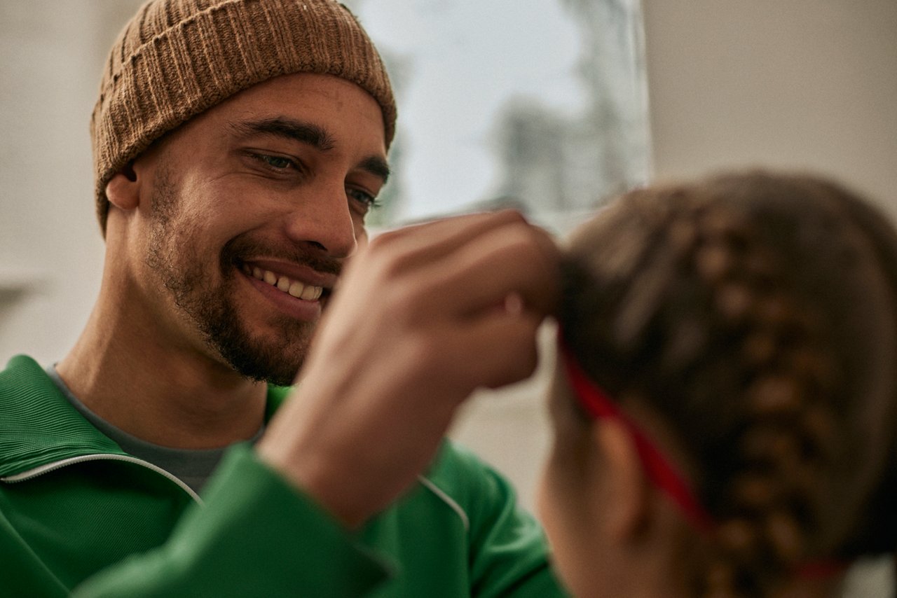 Persoon verzorgt gevlochten haar van kind
