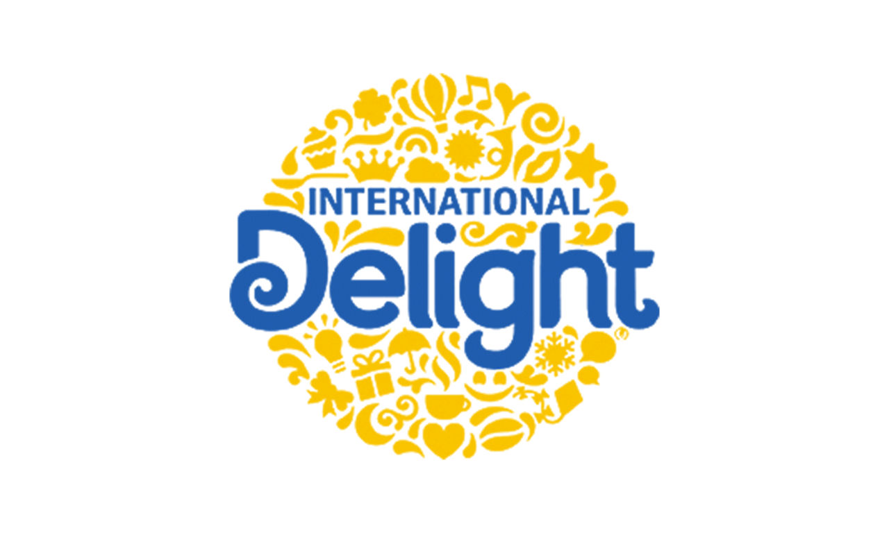 Logo d'International Delight, avec un cercle jaune rempli d'illustrations ludiques de friandises et de saveurs.
