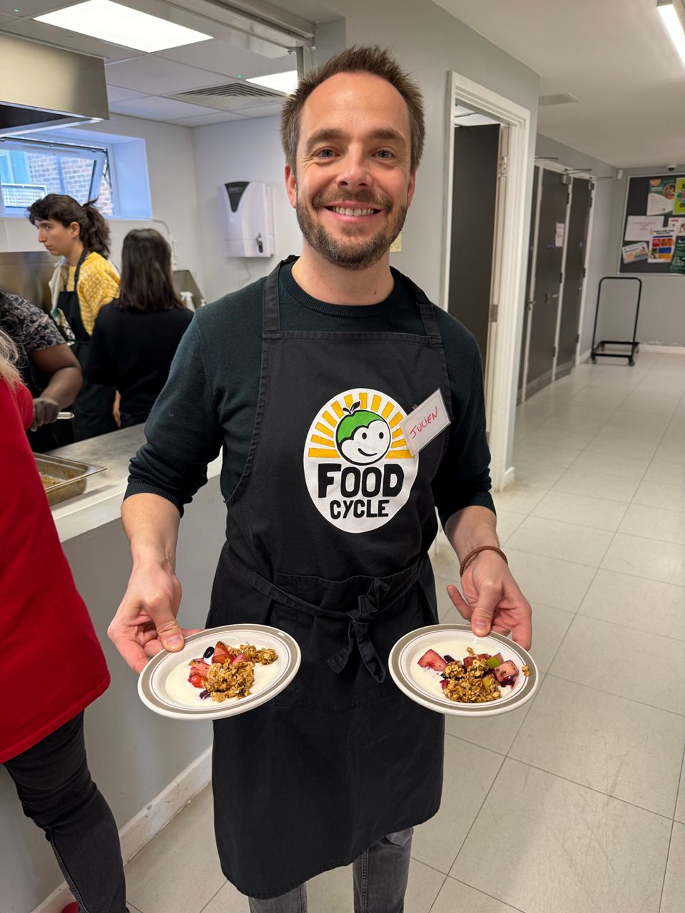 A man holds two plates while volunteering 