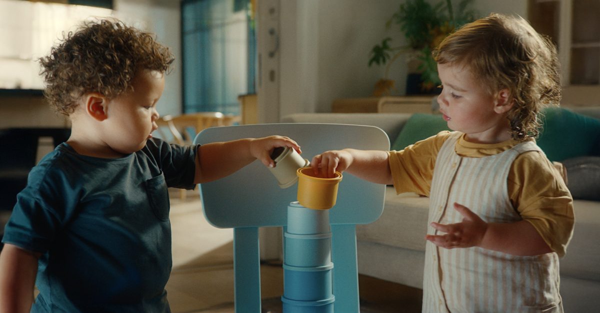 Kind trinkt aus einem Becher am Tisch