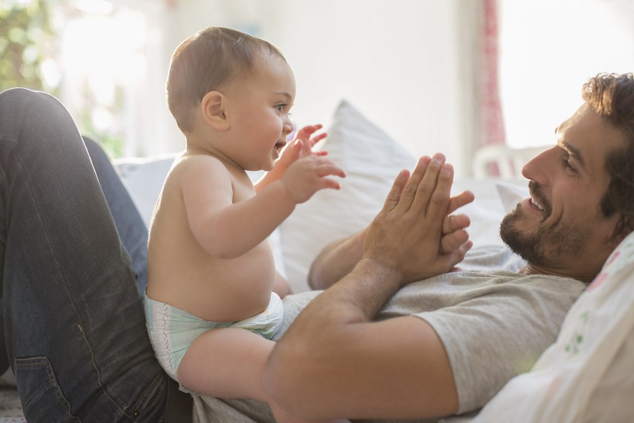 Baby van 6 maanden speelt en heeft interactie met een ouder, wat belangrijke ontwikkelingsmijlpalen en groei illustreert.