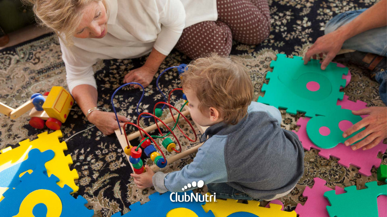 Niño rodeado de abuelos jugando