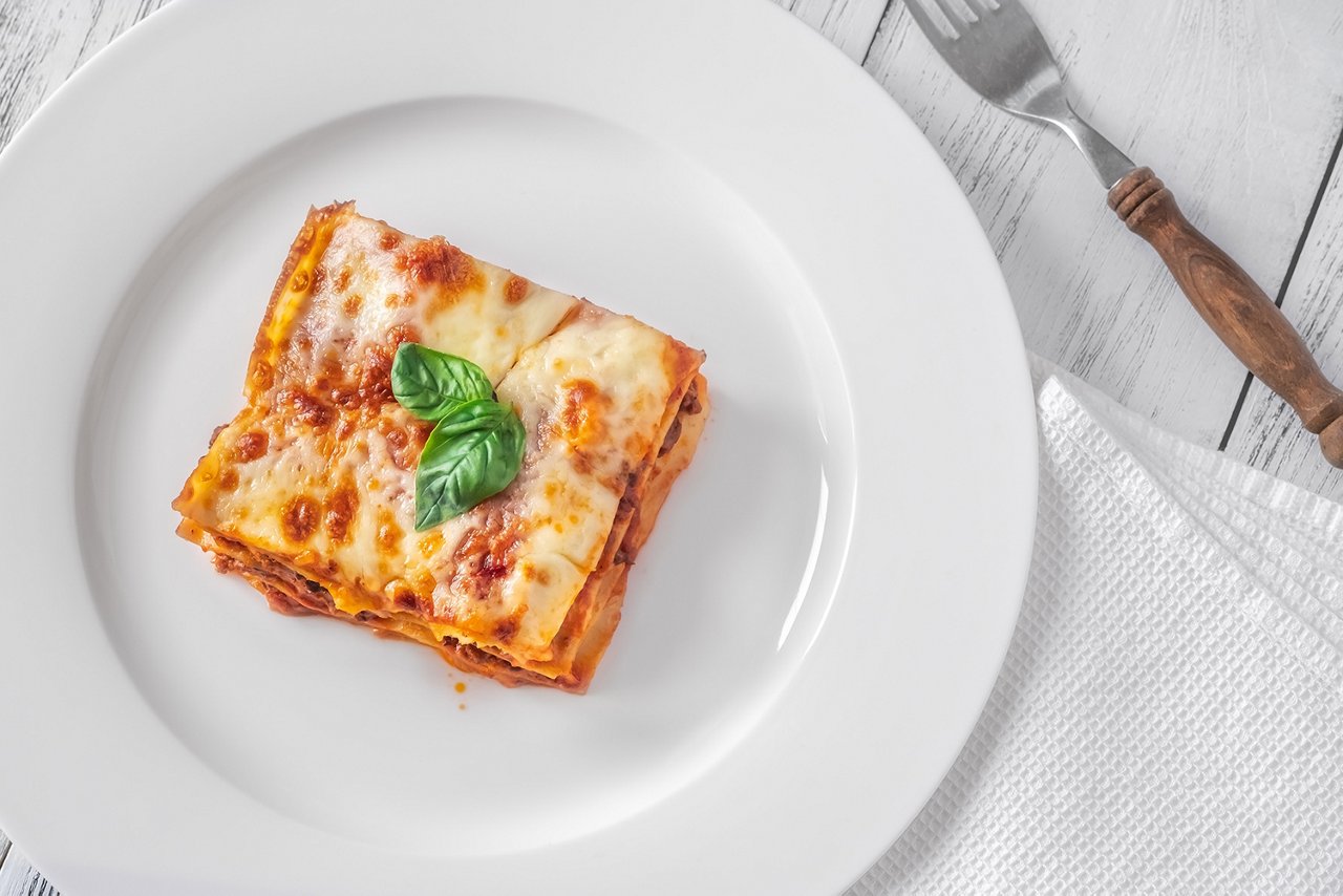 Portion of traditional italian lasagne on white plate