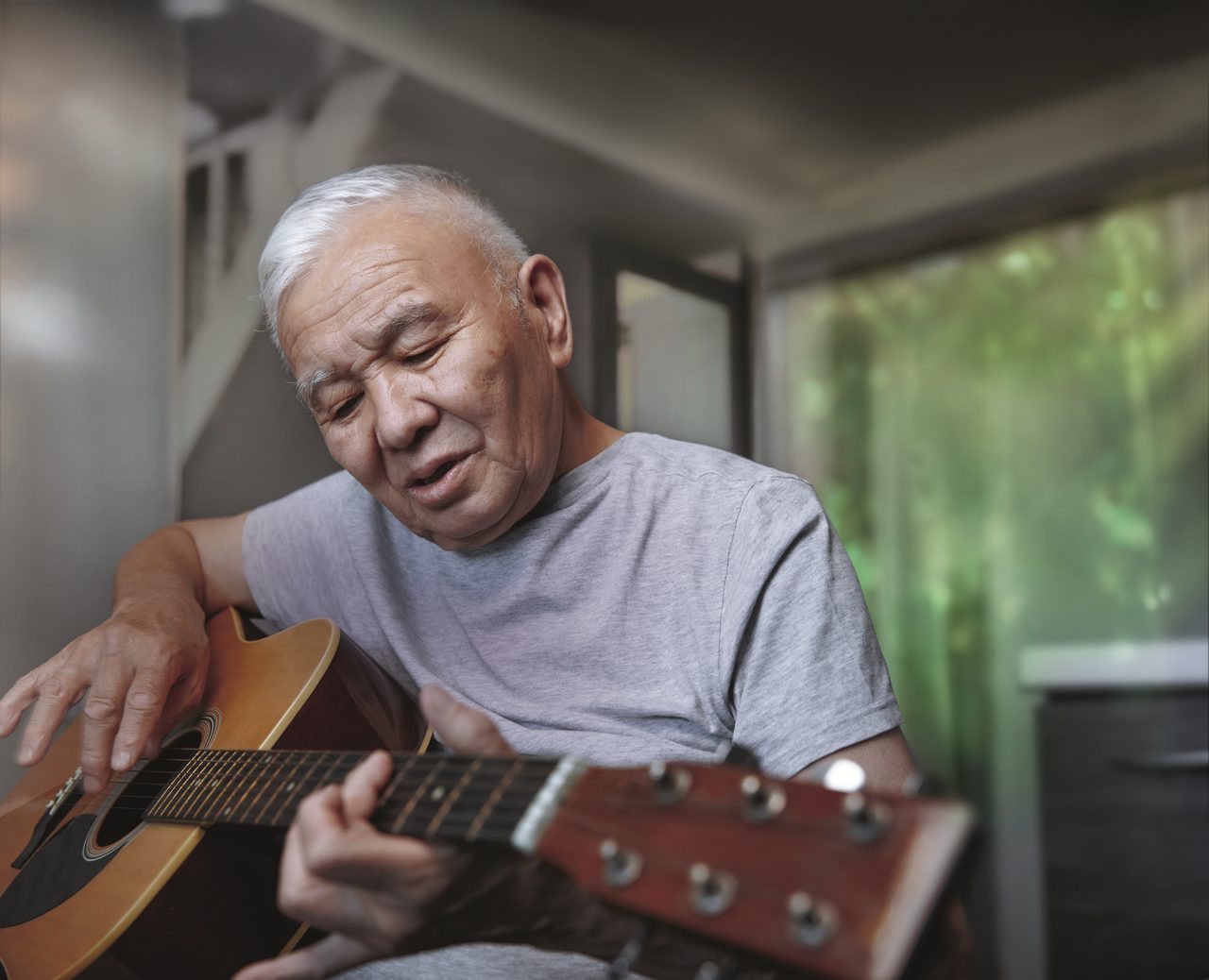Male cancer patient playing guitar
