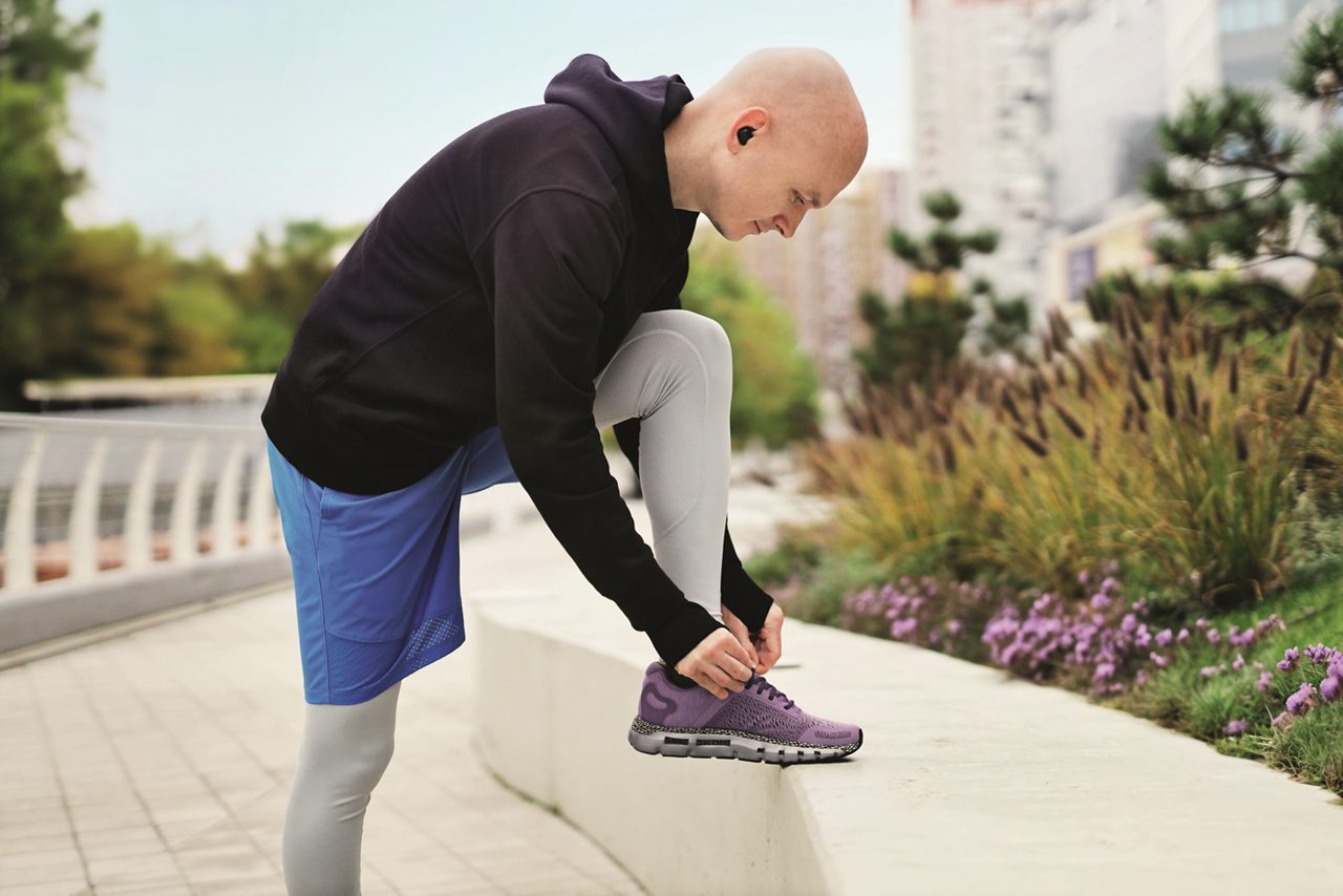 Male cancer patient tying shoe lace