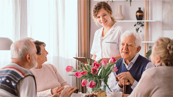 Enfermera atendiendo a un grupo de adultos mayores 