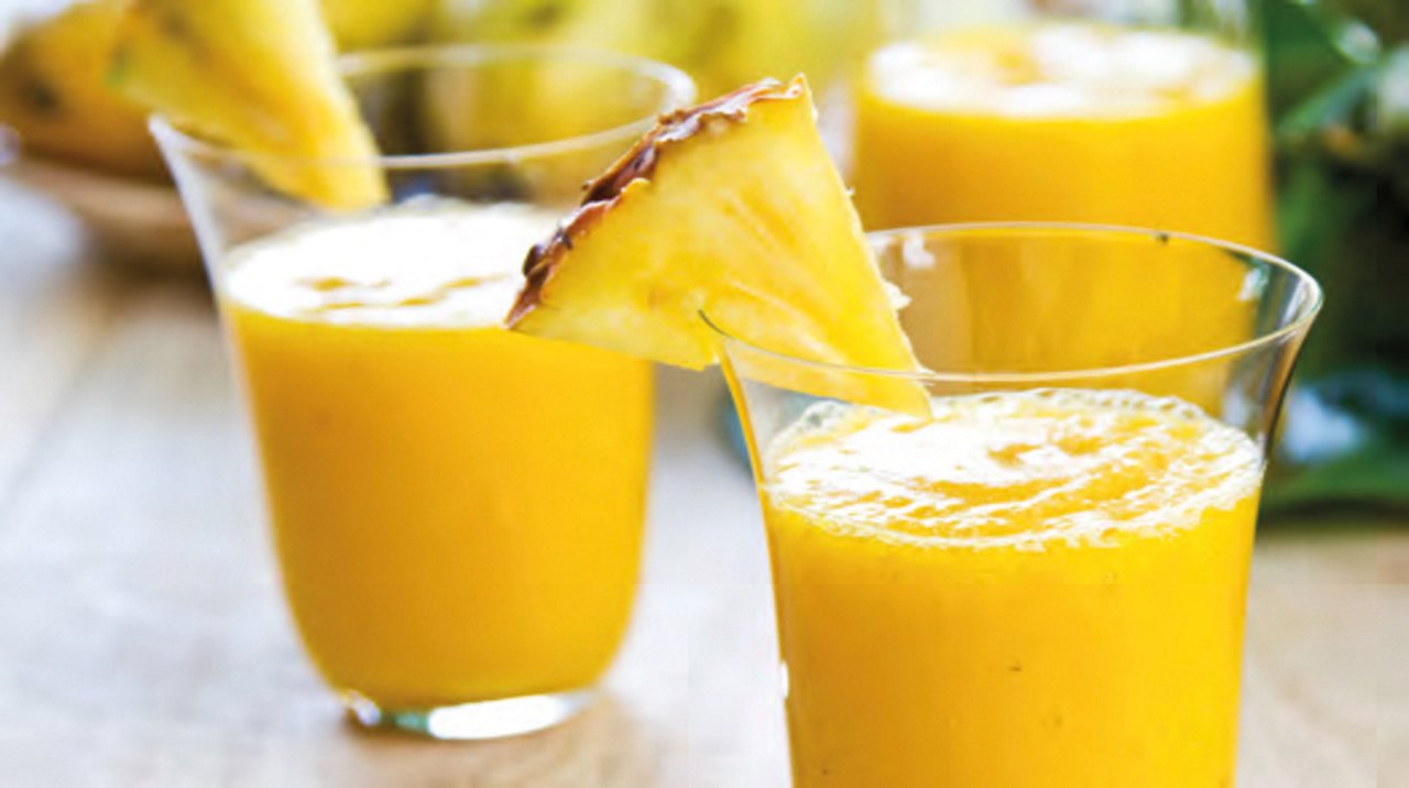 Mango with pineapple smoothie in jug and glasses