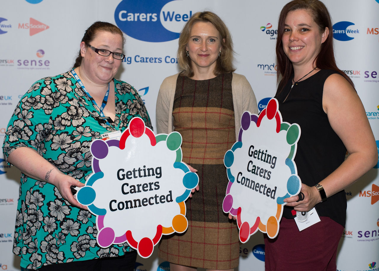 Nutricia Carers Week: Three women holding "Getting Carers Connected" signs