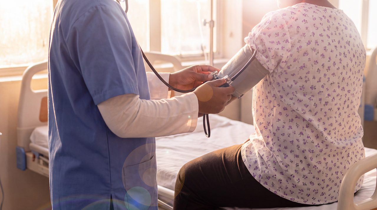 AI generated image of male doctor taking the blood pressure of female breast cancer patient.