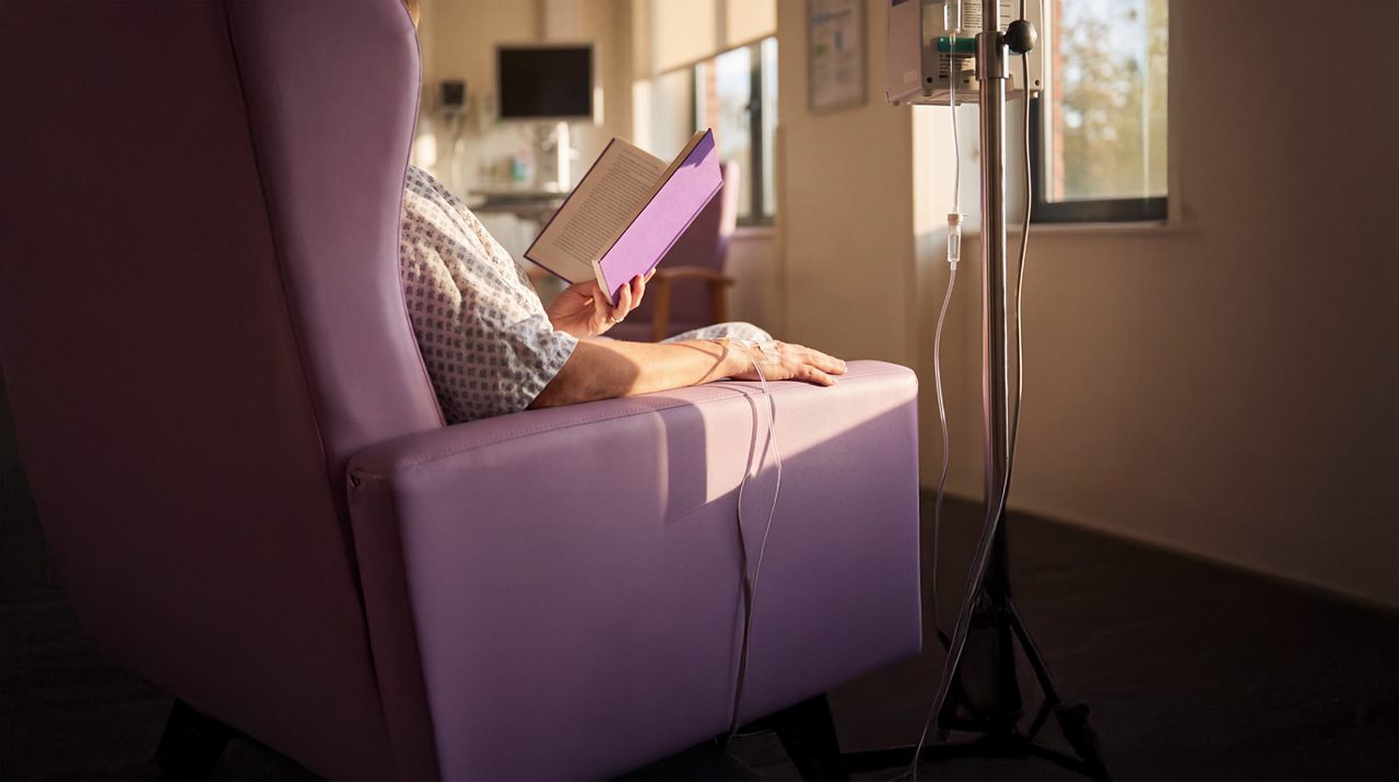 AI generated image of male cancer patient seated receiving immunotherapy.