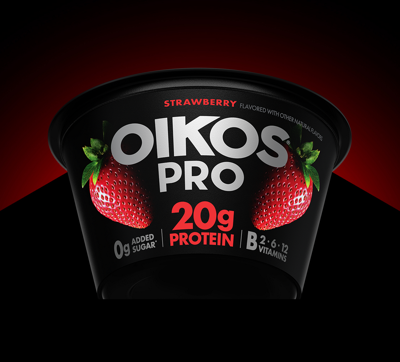 A cup of the rennovated Oikos Pro strawberry cup highlighted by a red light in the background.