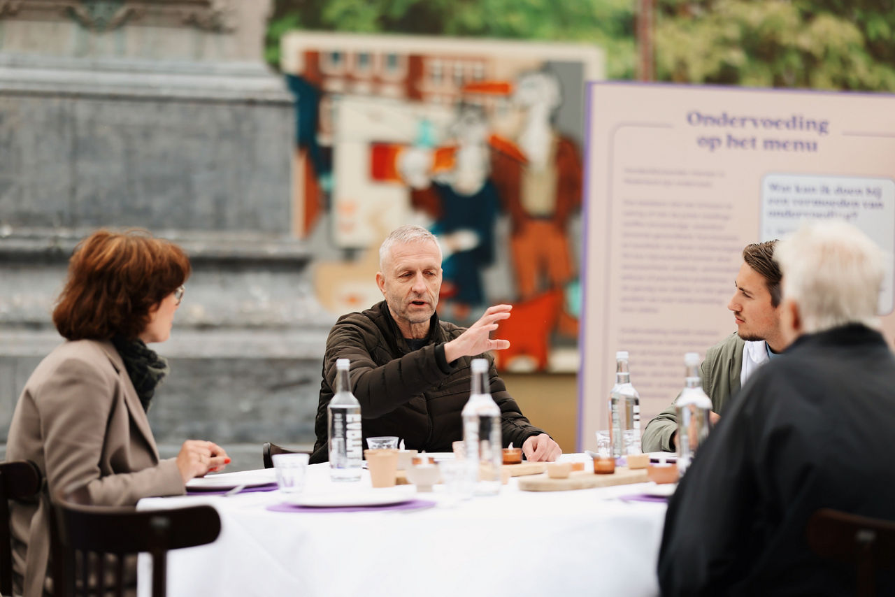 Mensen aan tafel tijdens lancering Ondervoeding op het menu