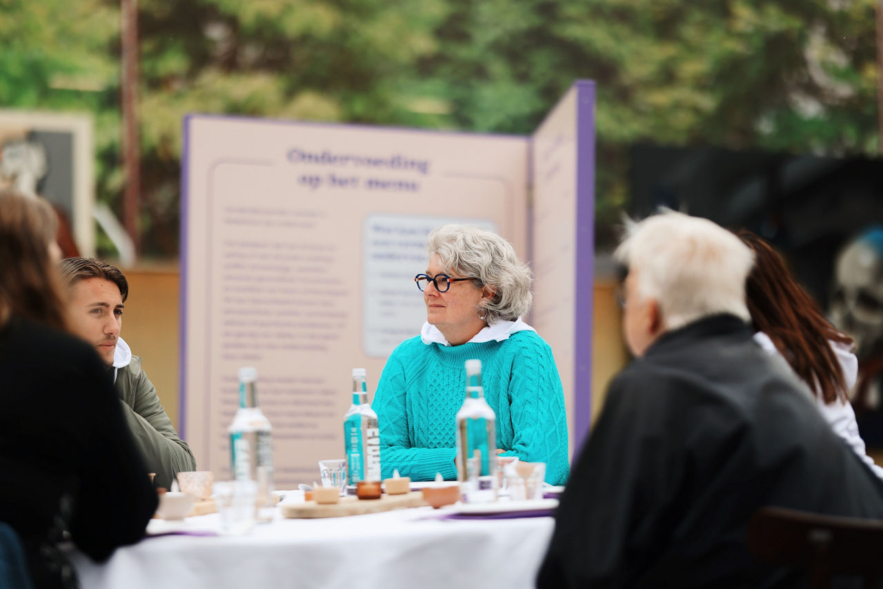 Mensen aan tafel tijdens campagne Ondervoeding op het menu