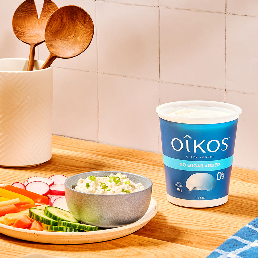 L'image illustre une assiette de légumes coupés à côté d'un pot de yogourt Oikos de Danone.