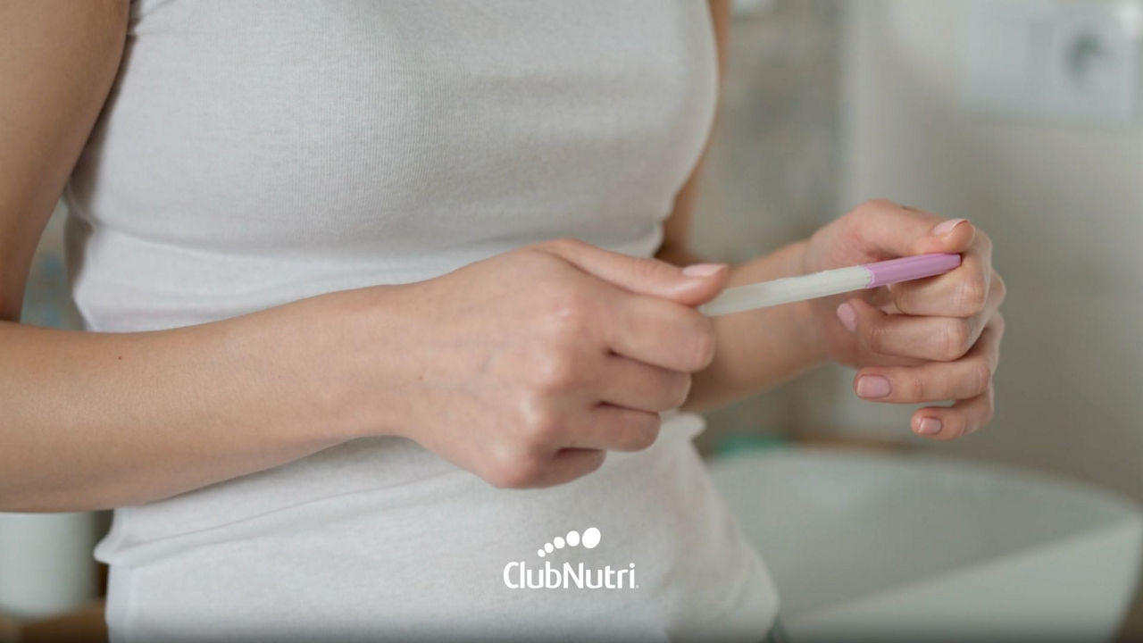 Mujer con test de embarazo en mano