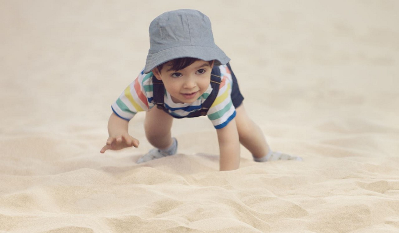 Bébé rampe dans le sable