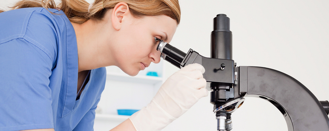 Donna guarda al microscopio