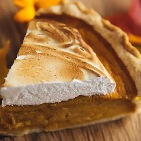 Slice of pumpkin pie with whipped topping