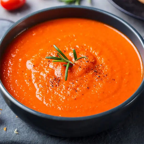 Fresh tomato soup in black bowl