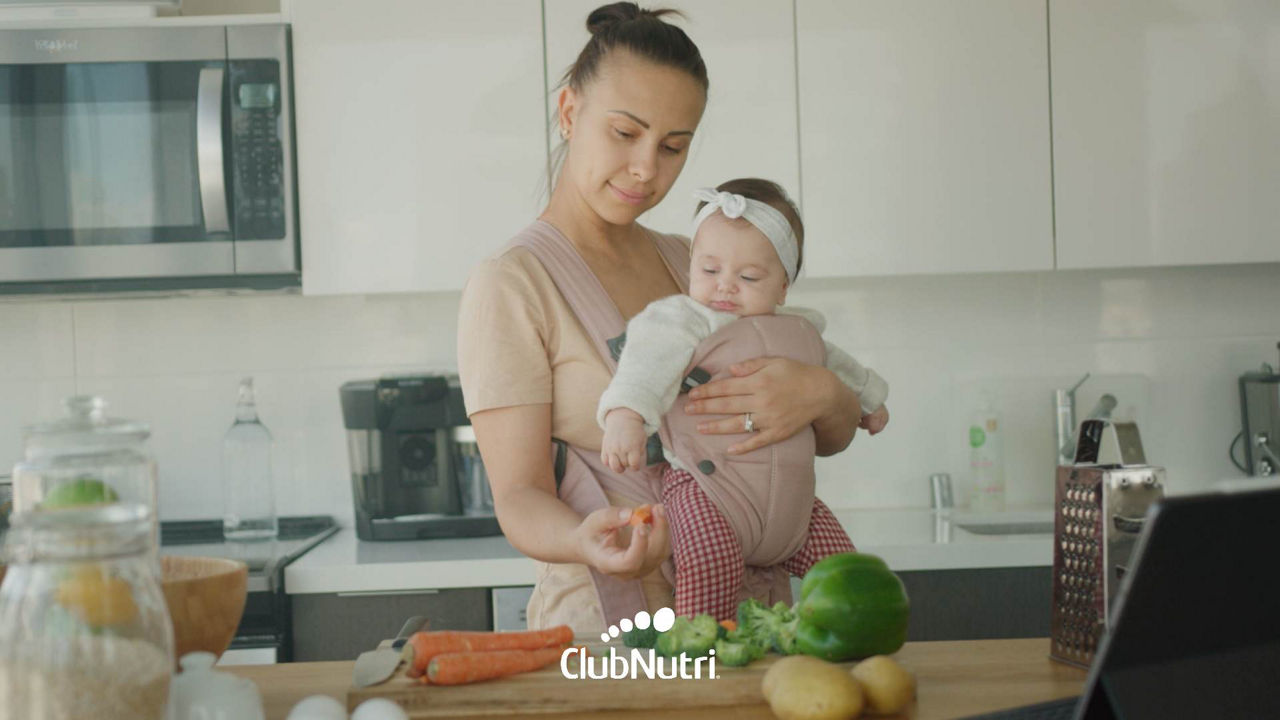 Madre cocinando con su bebé. 