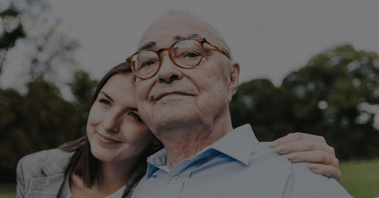 Woman with her arm around elderly father