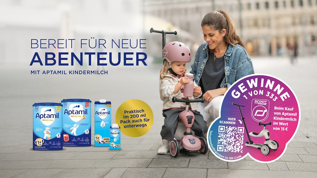 Kind trinkt aus einem Becher am Tisch
