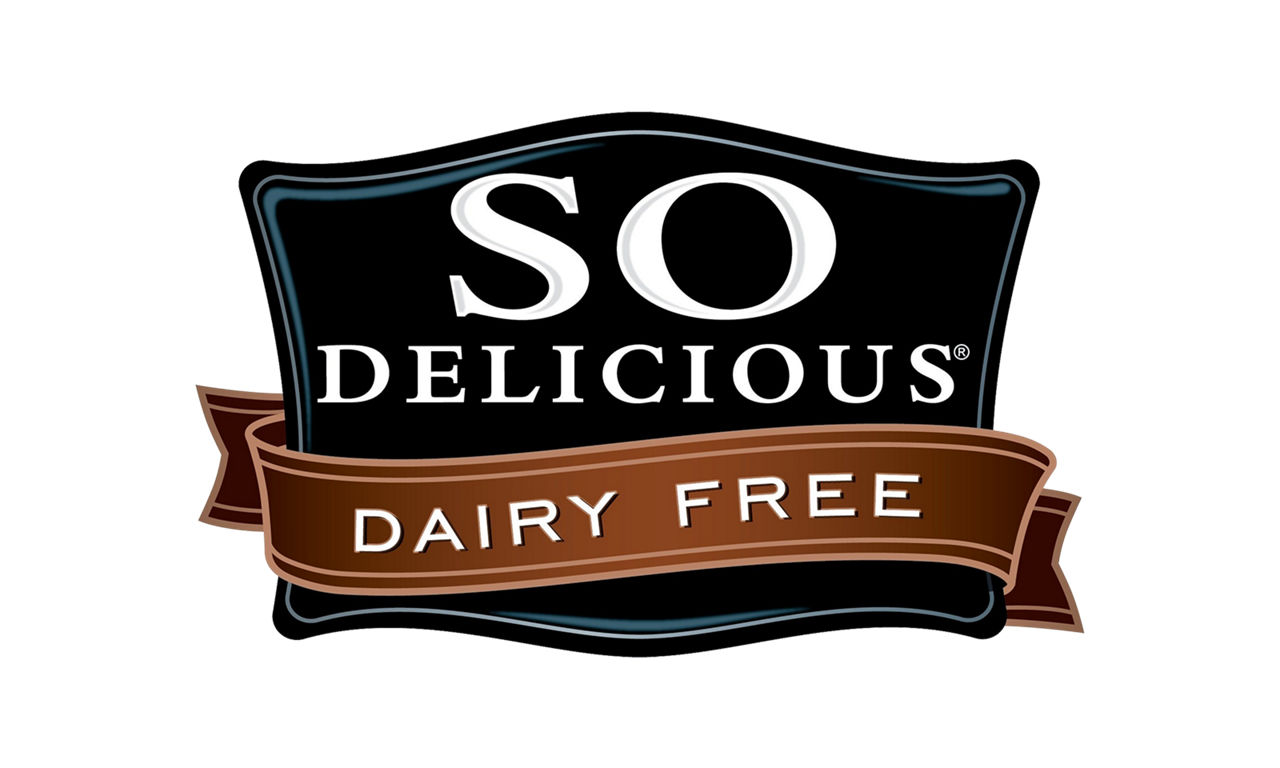 Logo de So Delicious Dairy Free, avec un écusson noir, une bannière marron et les mots "DAIRY FREE" bien en évidence.