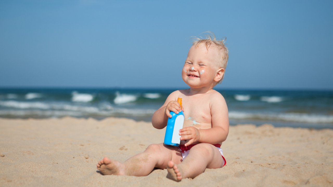 Kleines Baby Mädchen Strand Sonnencreme