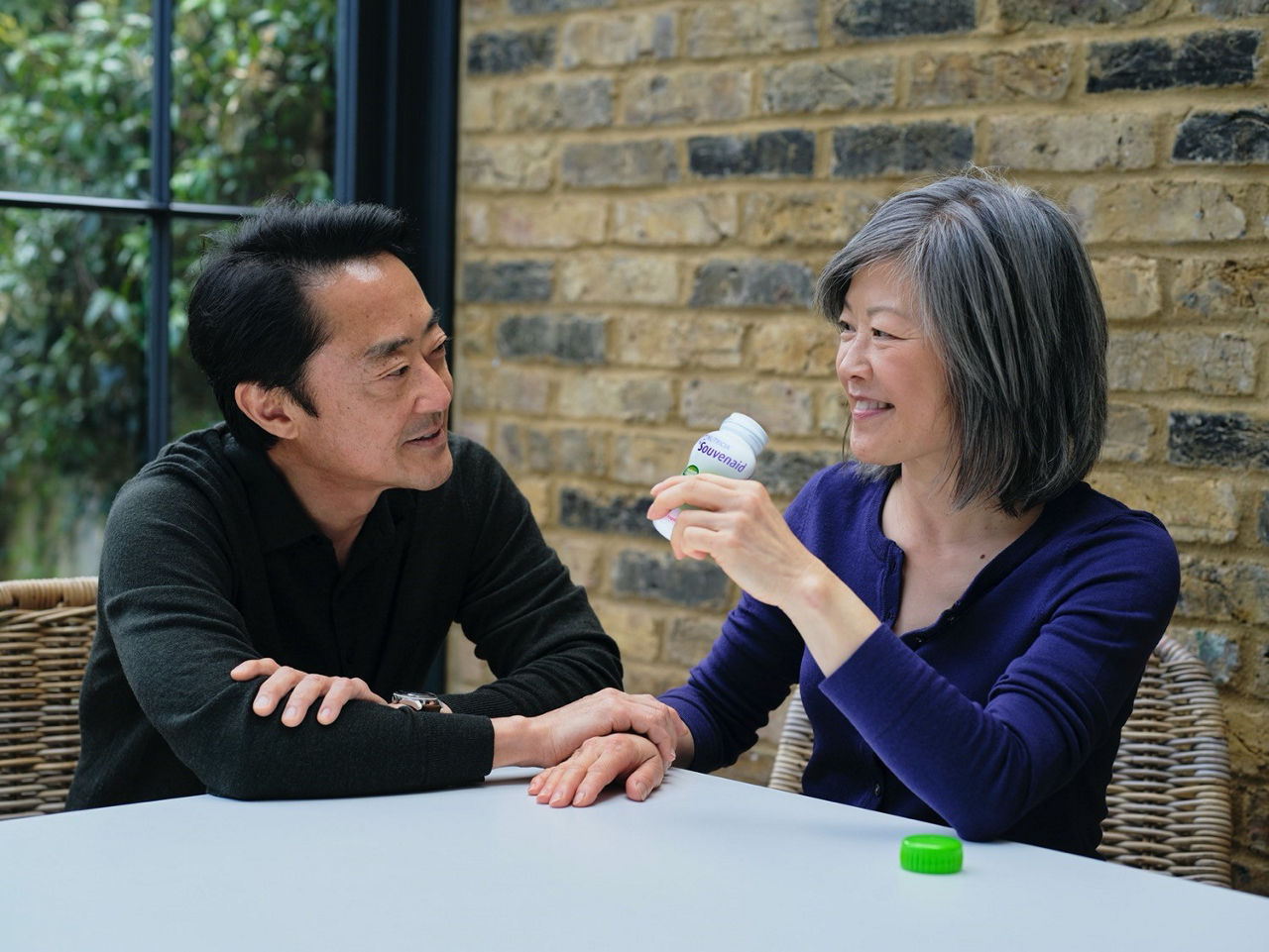 Man and woman sitting a table drinking souvenaid