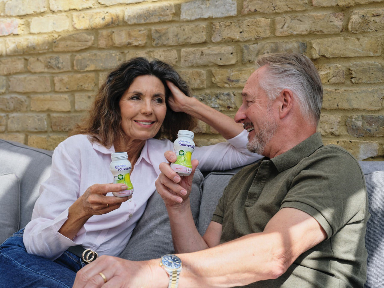 Man and woman sitting on couch drinking Souvenaid