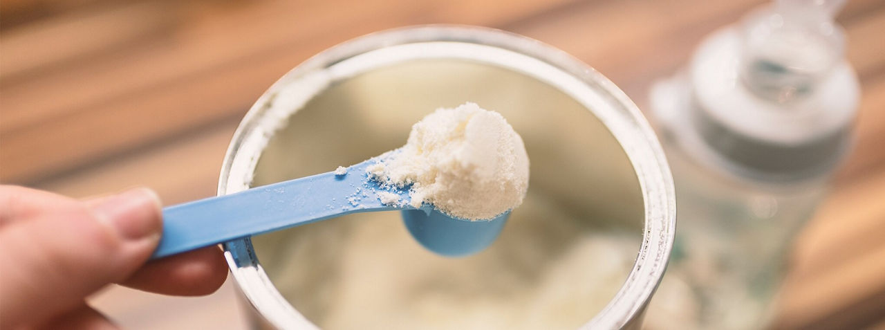 Baby formula being scooped out of a tin