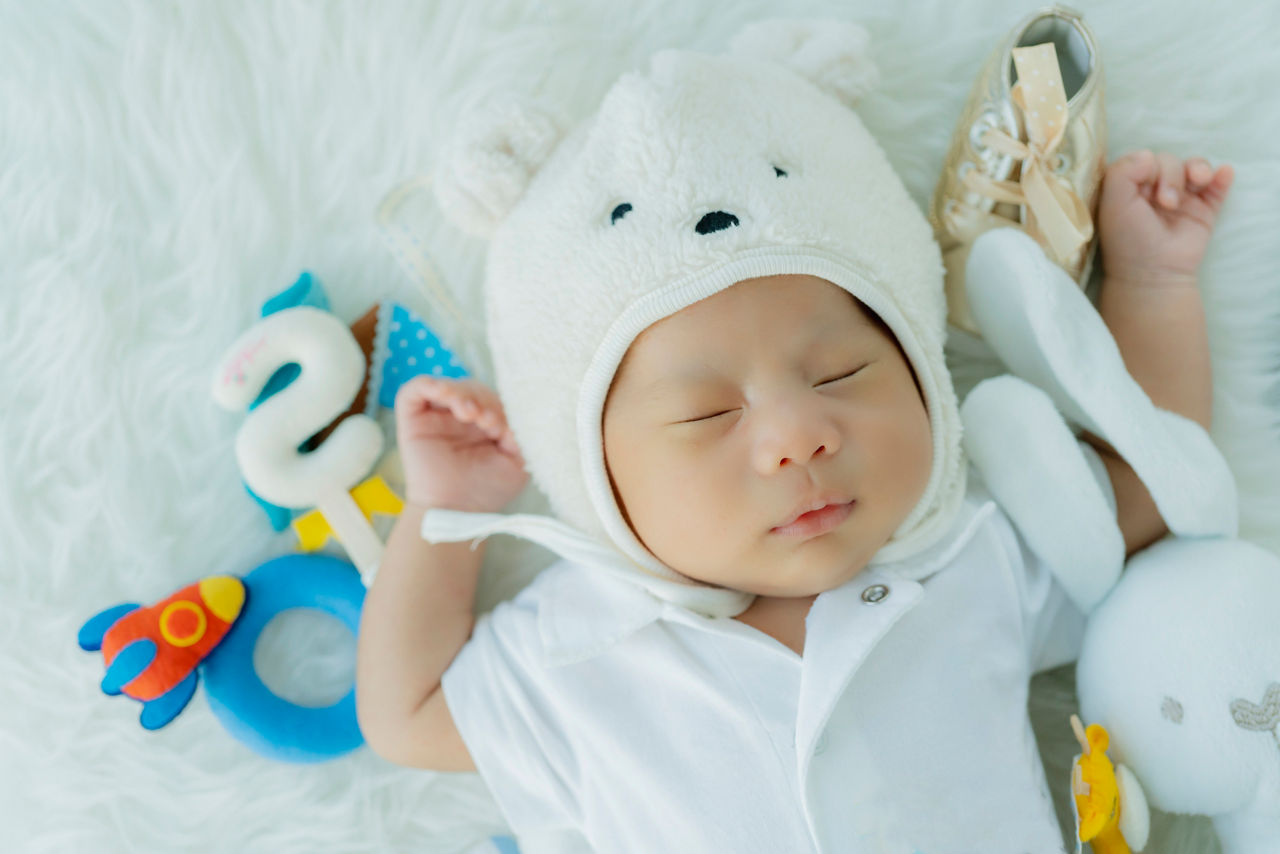 cute infant baby boy sleep with sweet dream and peaceful white soft bed