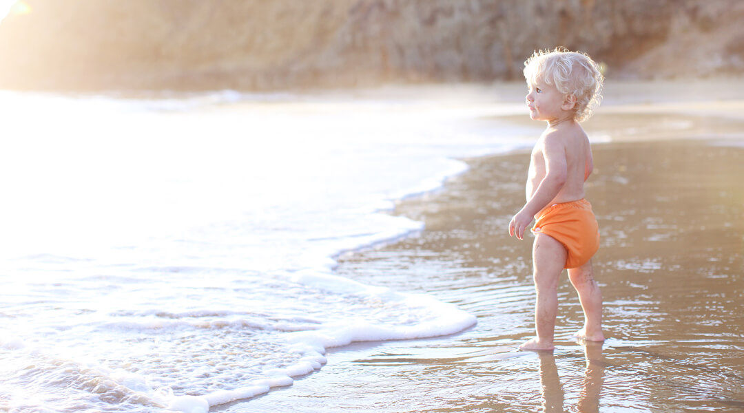 Baby with cloth nappies on the beach