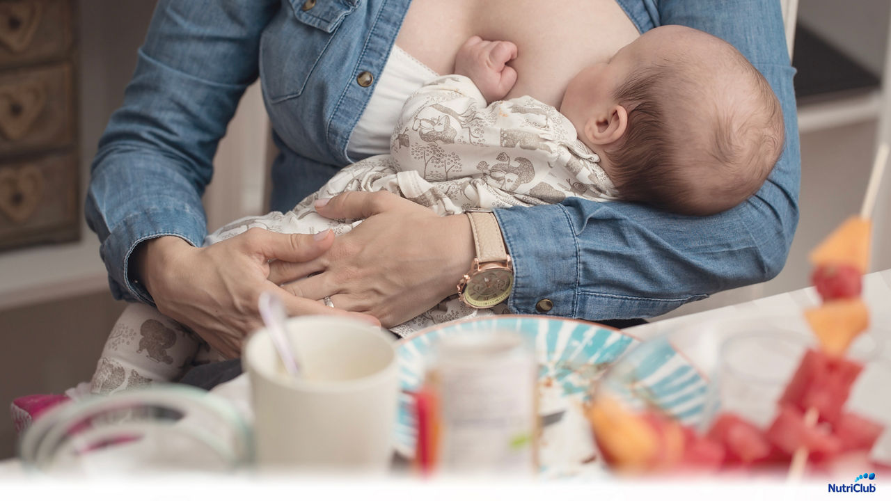 woman-eating-and-breastfeeding-baby