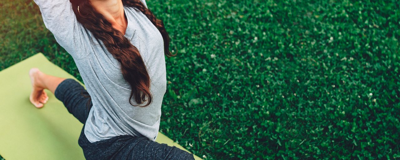 Donna fa yoga in giardino