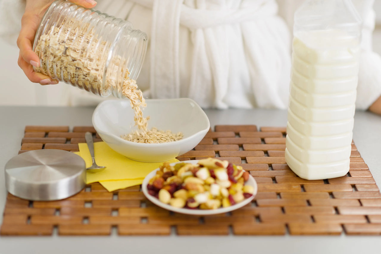 Closeup on woman putting oatmeal into plate